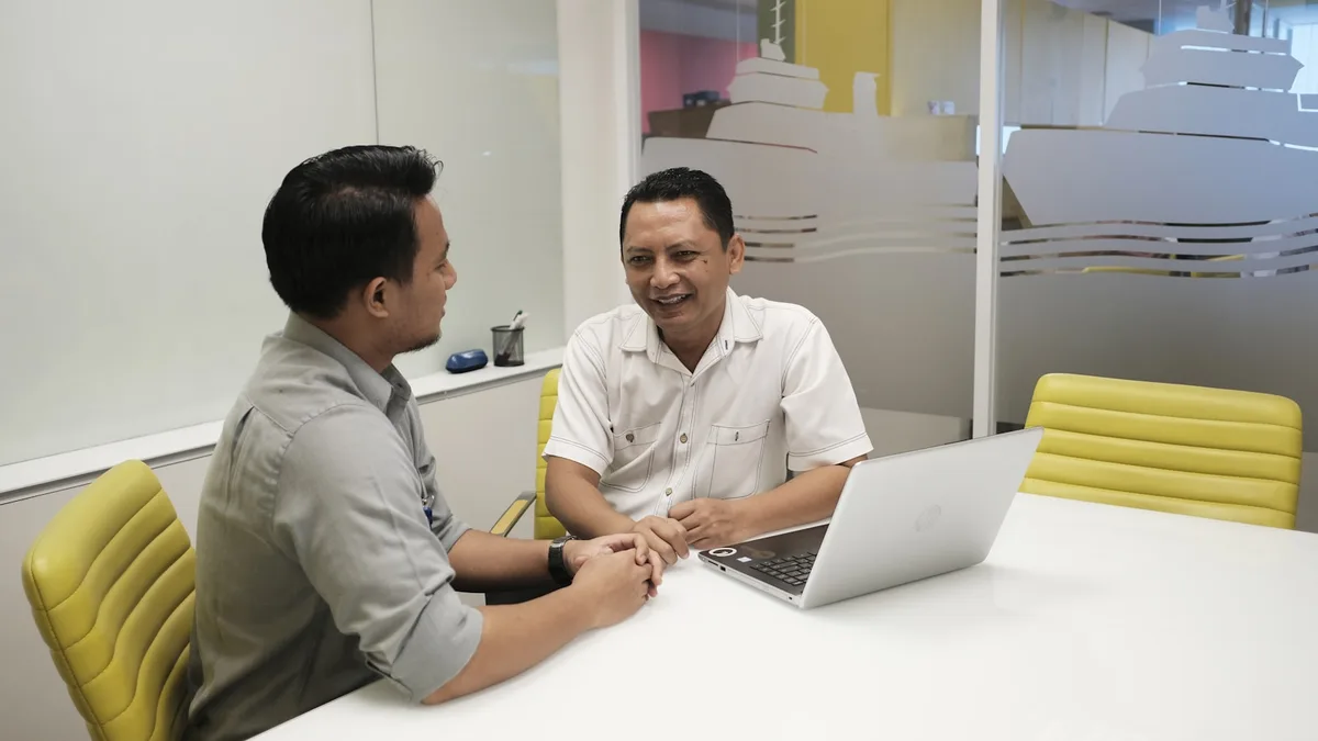 Workspace tim bisnis dengan laptop, dashboard workflow, dan dokumen proses.