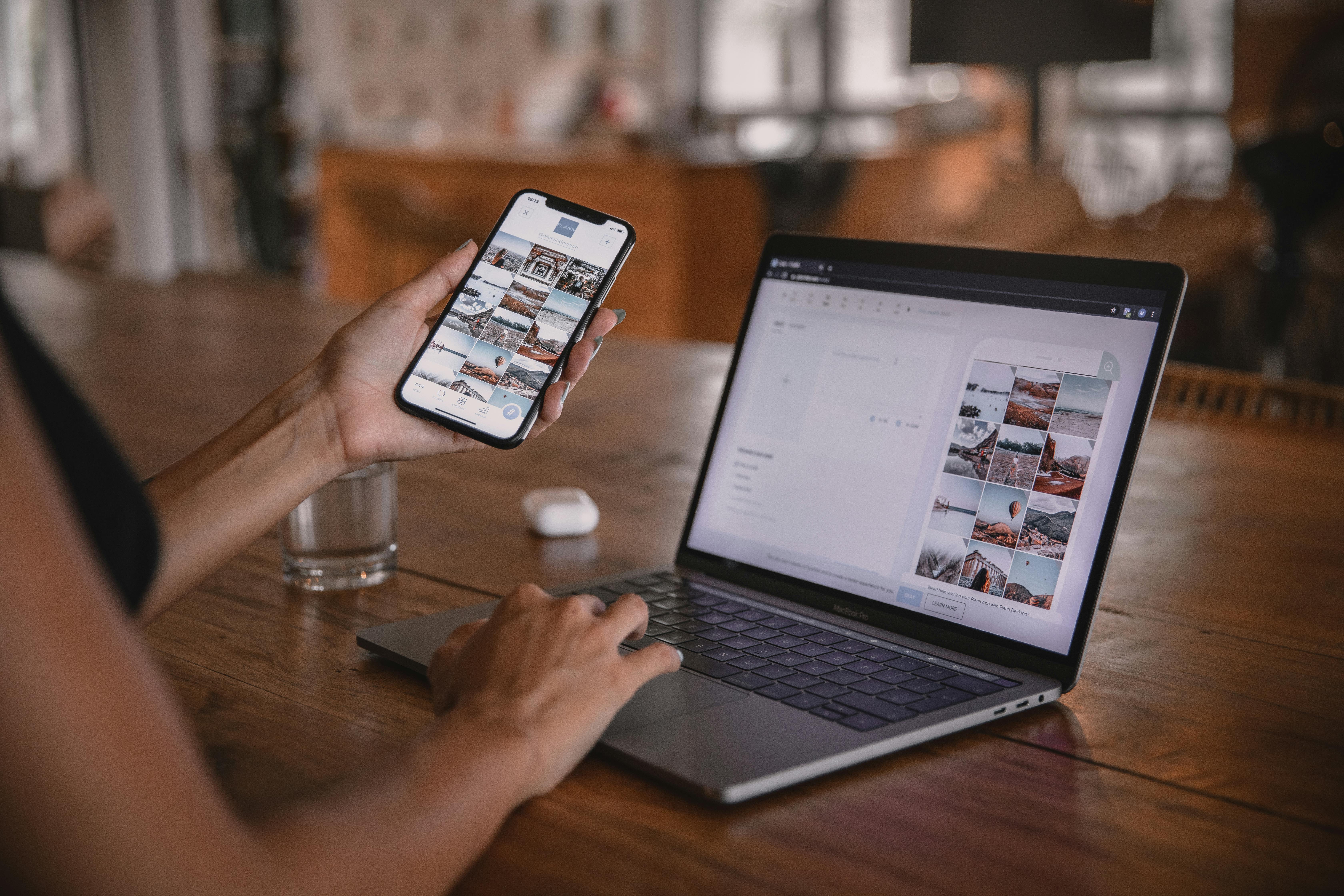 Profesional melihat smartphone dan laptop untuk mengecek jalur Google Maps ke website bisnis