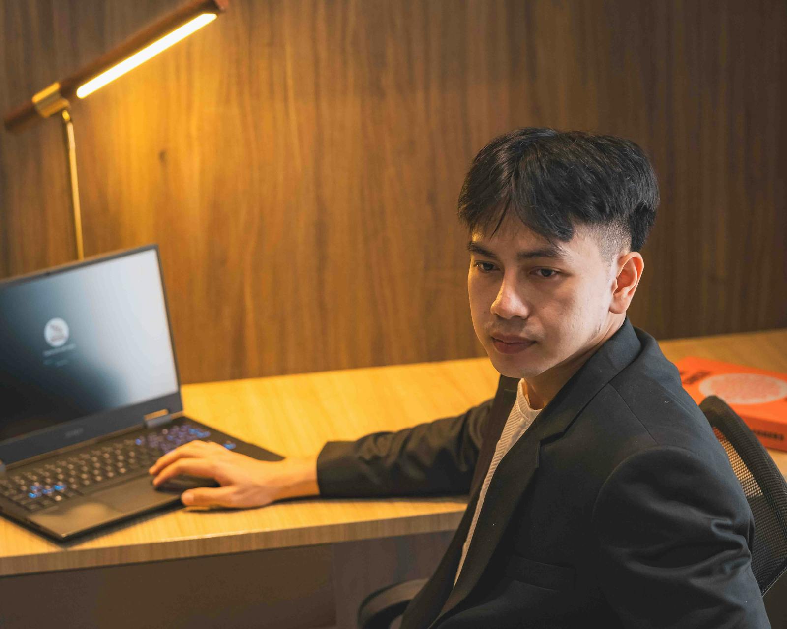 Profesional bisnis meninjau lead dari website di laptop dengan ponsel siap untuk follow-up pelanggan.