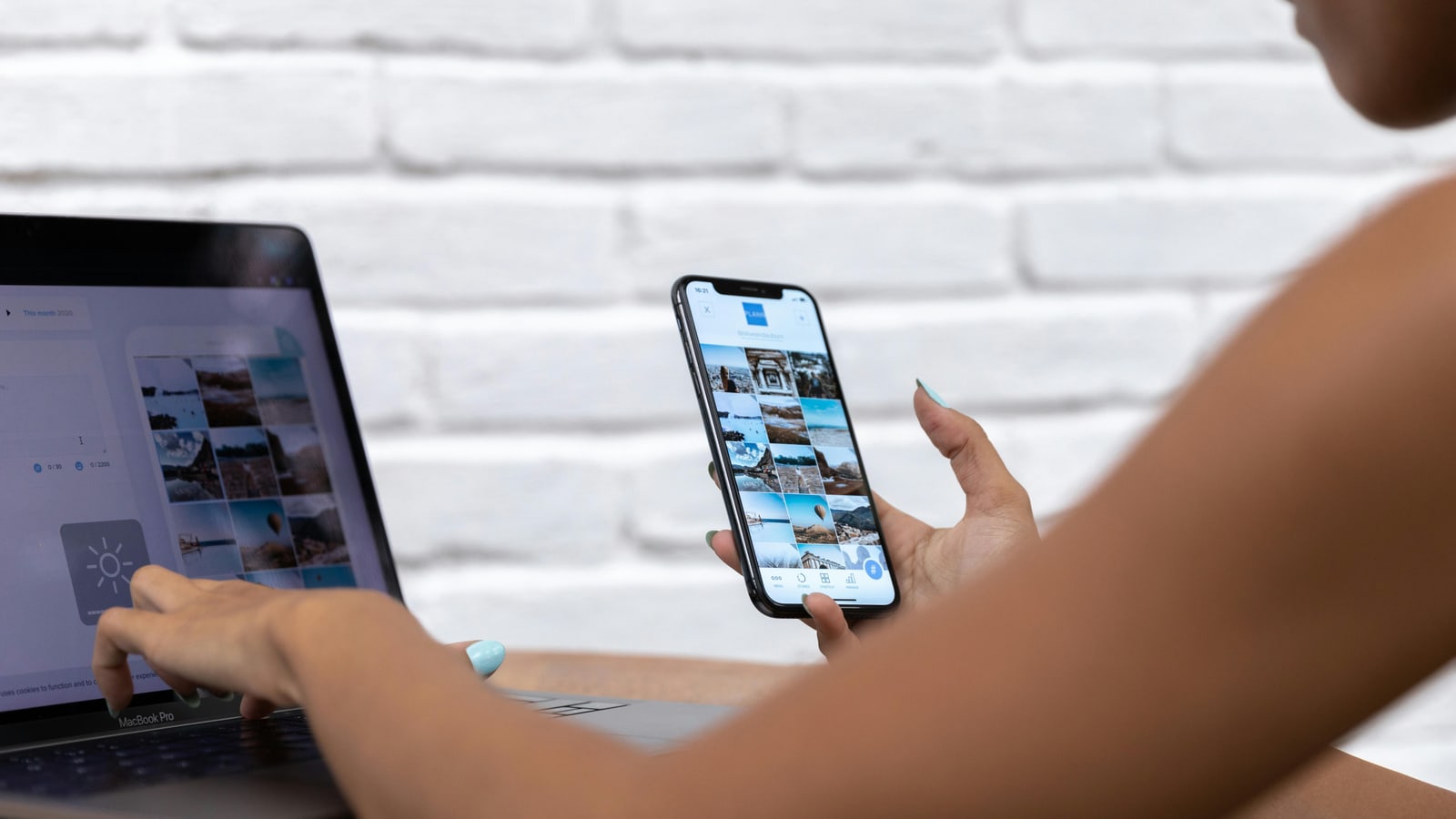 Pemilik bisnis memakai laptop dan smartphone untuk mengecek website setelah calon pelanggan melihat konten brand